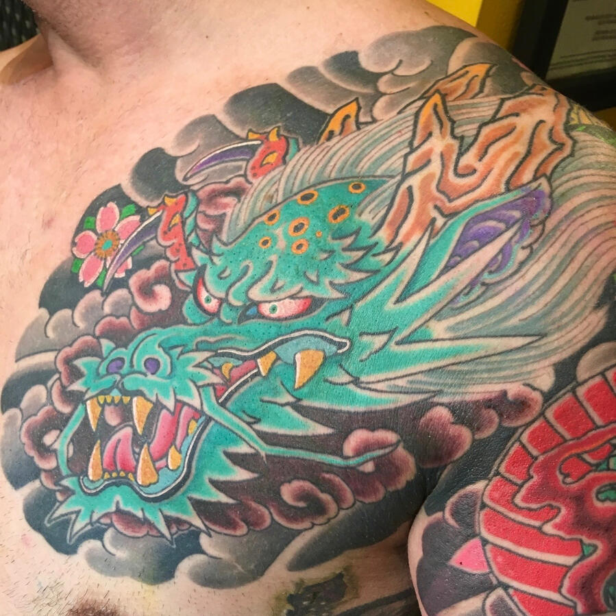 Japanese dragon half sleeve and chest piece tattoo. By Ezra Traditional Japanese dragon tattoo chest plate in bright bold color